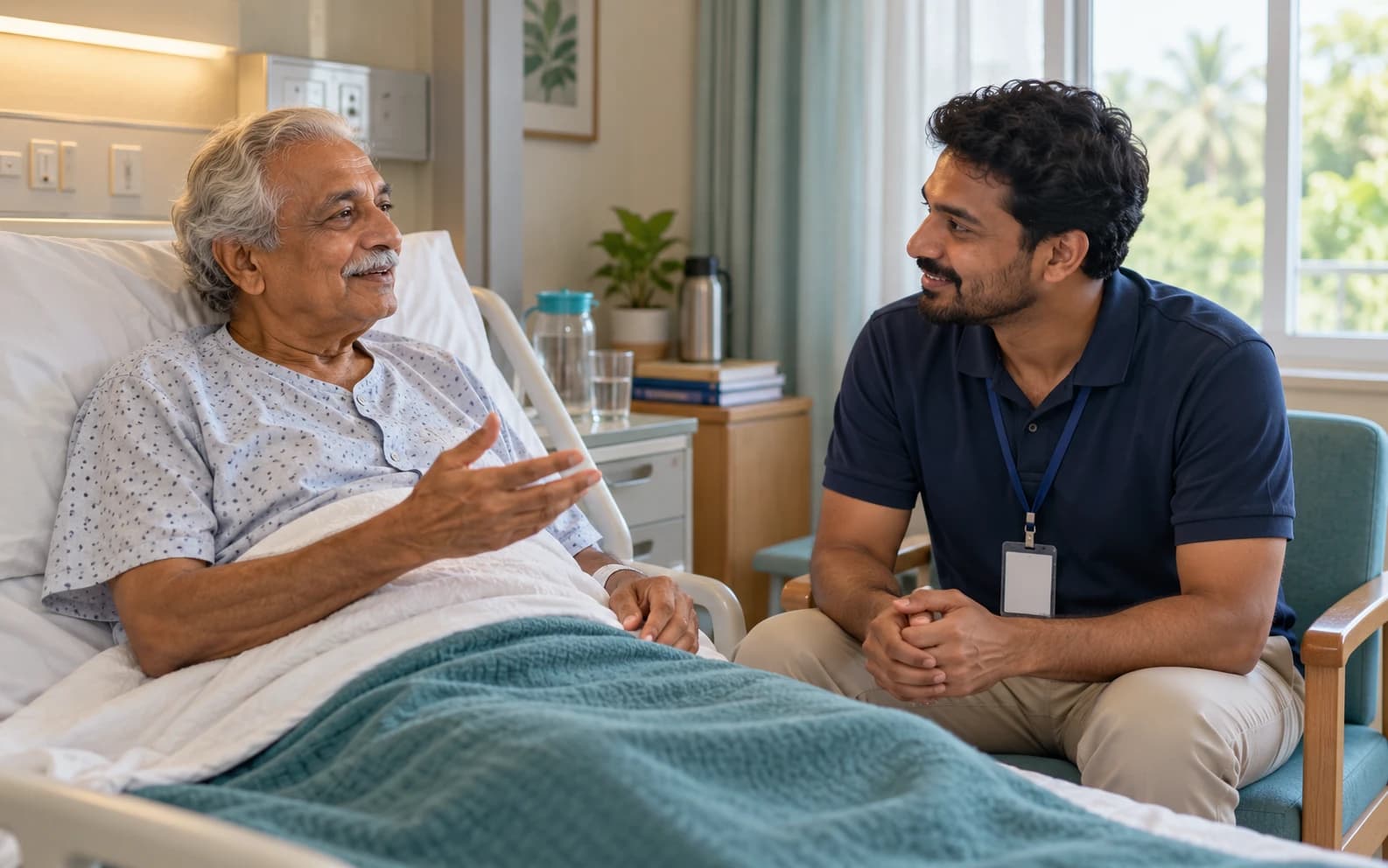 Doczo hospital bystander talking with an older man at his hospital bedside in Kozhikode
