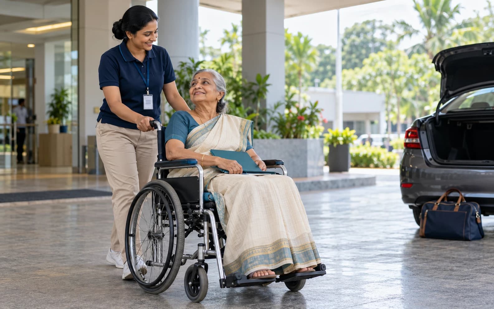 Doczo companion wheeling an older woman to a waiting car after hospital discharge in Kozhikode